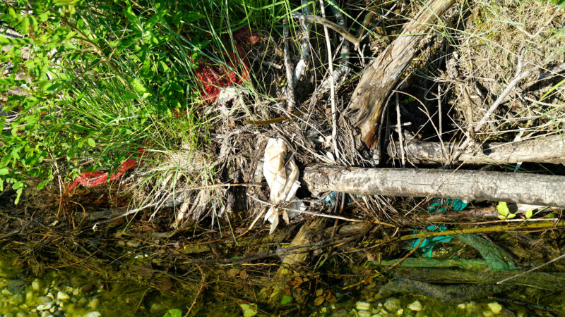 Müll als Treibgut im Flussbett